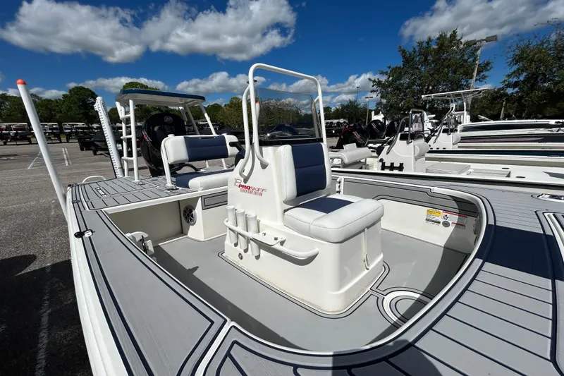 Slide: The Image of 2025 Mako 18 Pro Skiff Patriot Edition boat with seating, parked outdoors under blue sky. - 4