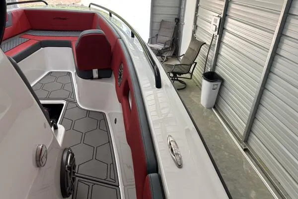 Slide: The Image of 2025 Concept 27' Open Deck boat with red and gray interior in a garage. - 46