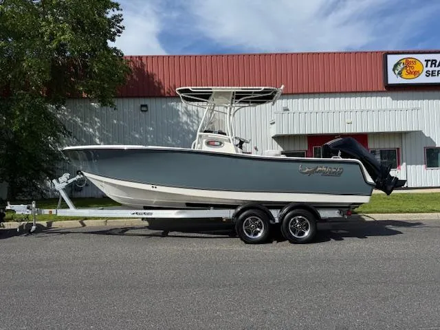 Slide: The Image of 2025 Mako 214 CC boat on trailer, parked outside a building. - 1