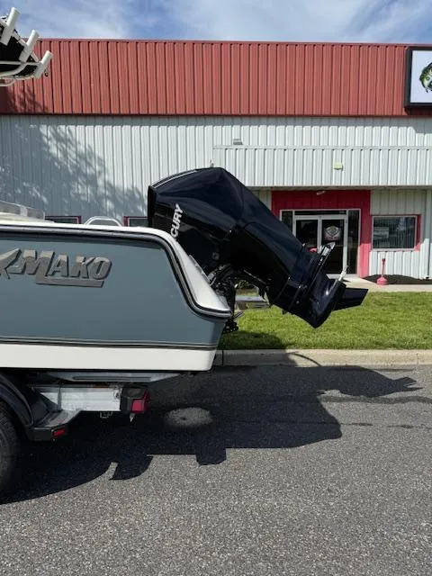 Slide: The Image of 2025 Mako 214 CC boat with outboard motor, parked outside a building. - 3