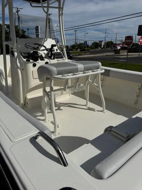 Slide: The Image of 2025 Mako 214 CC boat interior with steering console and seating, parked outdoors. - 7
