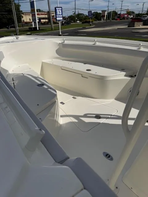 Slide: The Image of 2025 Mako 214 CC boat interior with seating and storage, displayed outdoors. - 9
