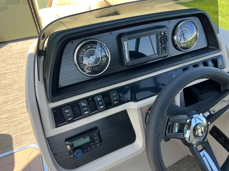 Slide: The Image of 2025 Godfrey Sweetwater 2286 Quad Social Tri-Toon dashboard with steering wheel and control panel. - 22