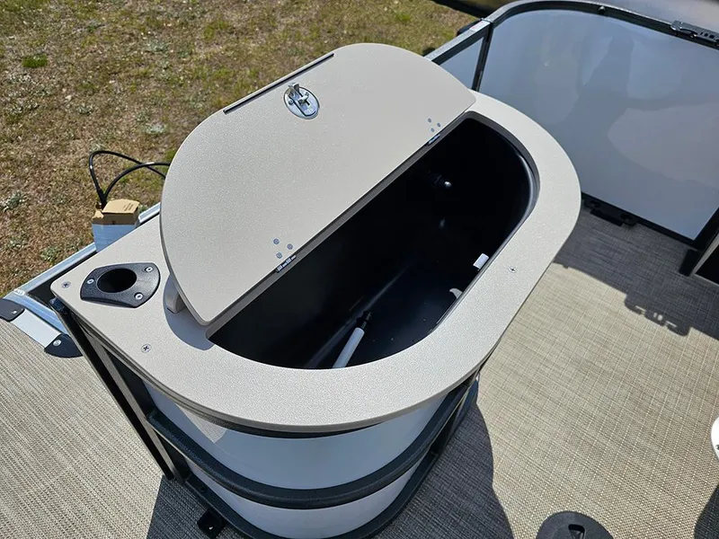 Slide: The Image of 2025 Bentley Pontoons 240 4-Point Fish livewell, open lid, beige interior, outdoor setting. - 12