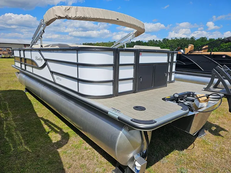 Slide: The Image of 2025 Bentley Pontoons 240 4-Point Fish pontoon boat on grassy area under blue sky. - 6