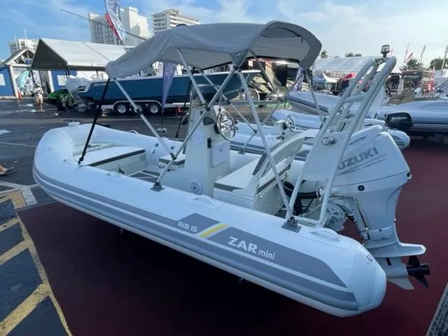 Slide: The Image of 2024 ZAR Mini RIB 15 Tender with Suzuki outboard motor, displayed at a boat show. - 12