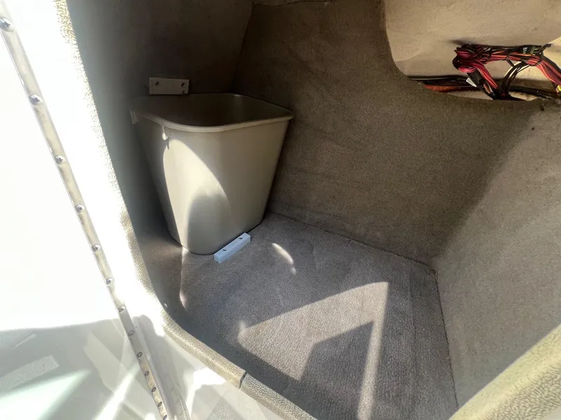 Slide: The Image of Storage compartment in a 2005 Sea Ray 220 Select boat, featuring a plastic bin. - 10