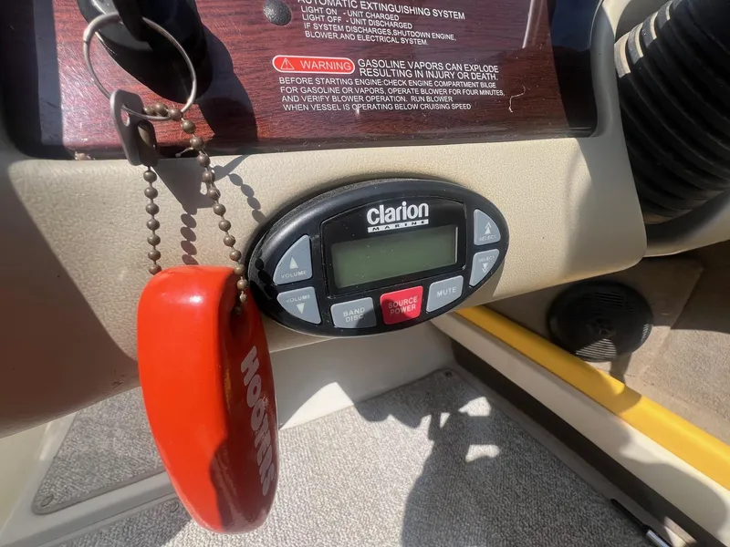 Slide: The Image of Boat dashboard with Clarion marine stereo and safety keychain, Sea Ray 220 Select, 2005 model. - 14