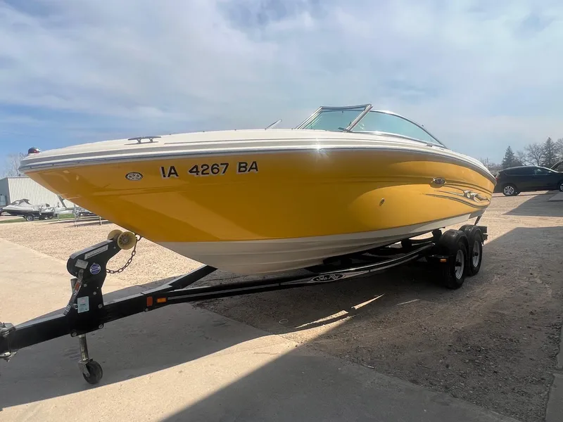Slide: The Image of 2005 Sea Ray 220 Select boat in bright yellow on a trailer, parked outdoors. - 2