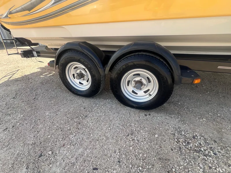 Slide: The Image of Trailer wheels of a 2005 Sea Ray 220 Select boat on gravel surface. - 25
