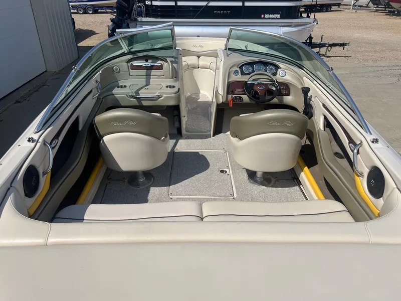 Slide: The Image of 2005 Sea Ray 220 Select boat interior with beige seating and dashboard controls. - 7