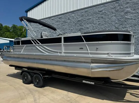 Slide: The Image of 2025 South Bay S224RS pontoon boat on trailer, silver exterior, parked outdoors. - 8