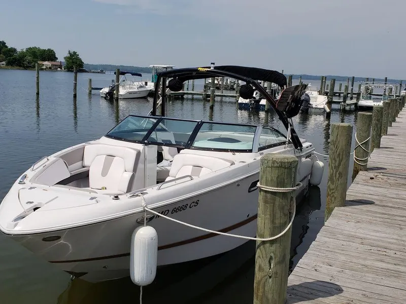 Slide: The Image of 2017 Four Winns H260 boat docked at a marina, calm water, clear sky. - 0