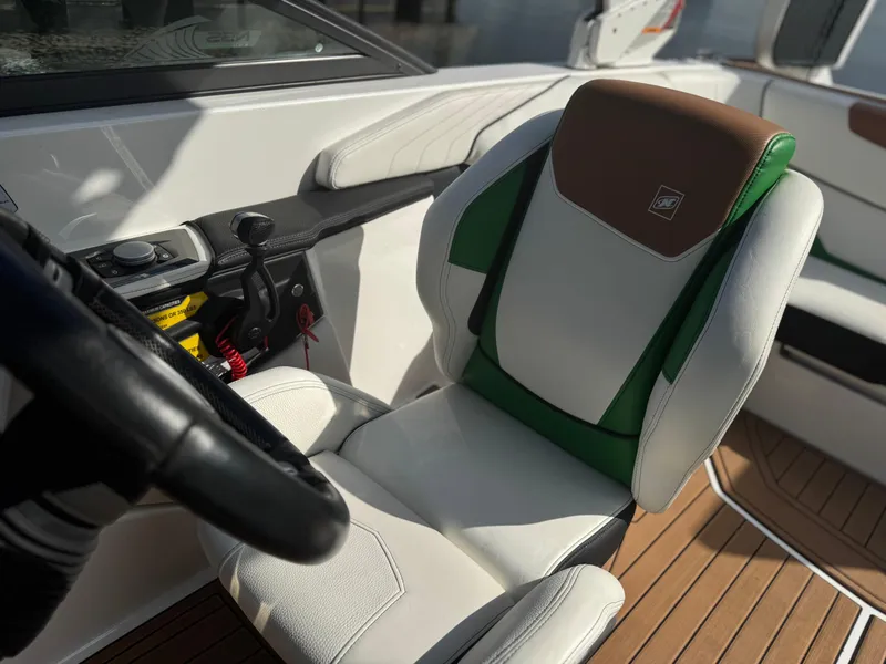 Slide: The Image of 2017 Nautique Super Air Nautique GS20 interior with white and green seating, steering wheel, and controls. - 21
