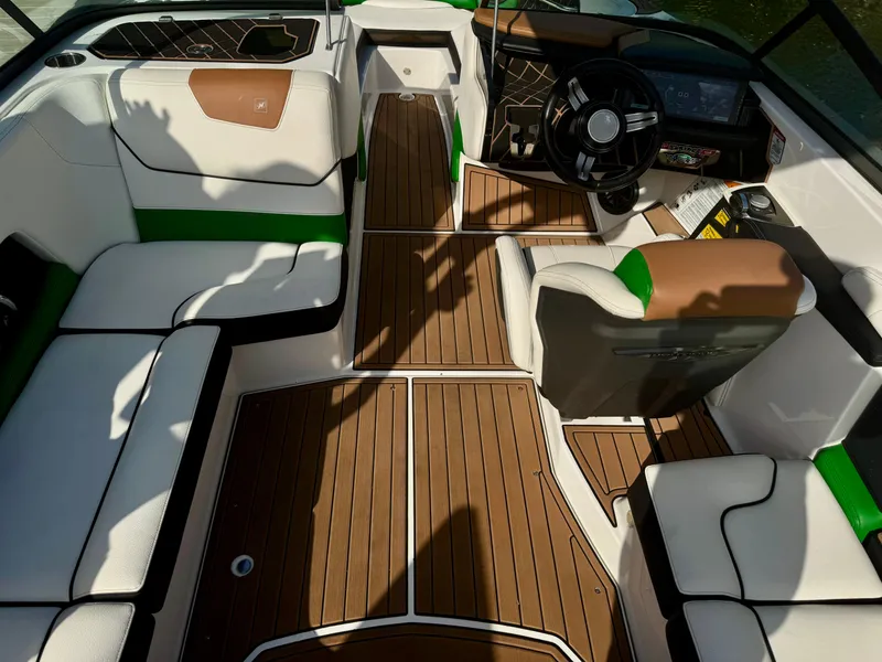 Slide: The Image of 2017 Nautique Super Air Nautique GS20 interior with brown and white seating, green accents. - 7