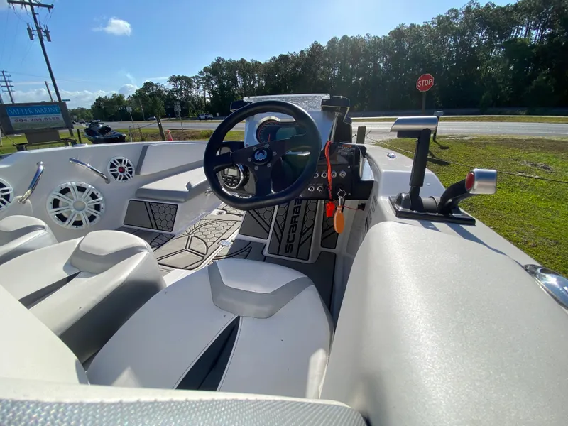 Slide: The Image of Interior view of 2018 Scarab 165 boat, featuring steering wheel and seating. - 10