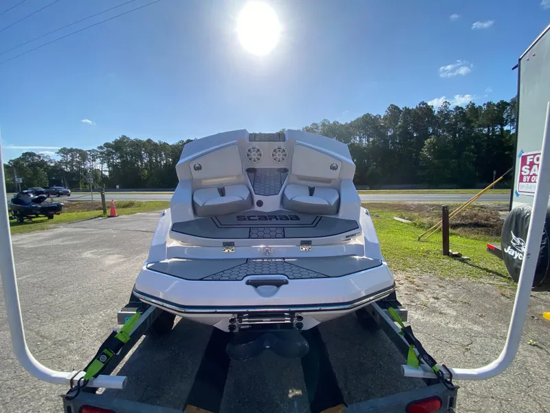 Slide: The Image of 2018 Scarab 165 boat on trailer under bright sun, parked near road. - 13