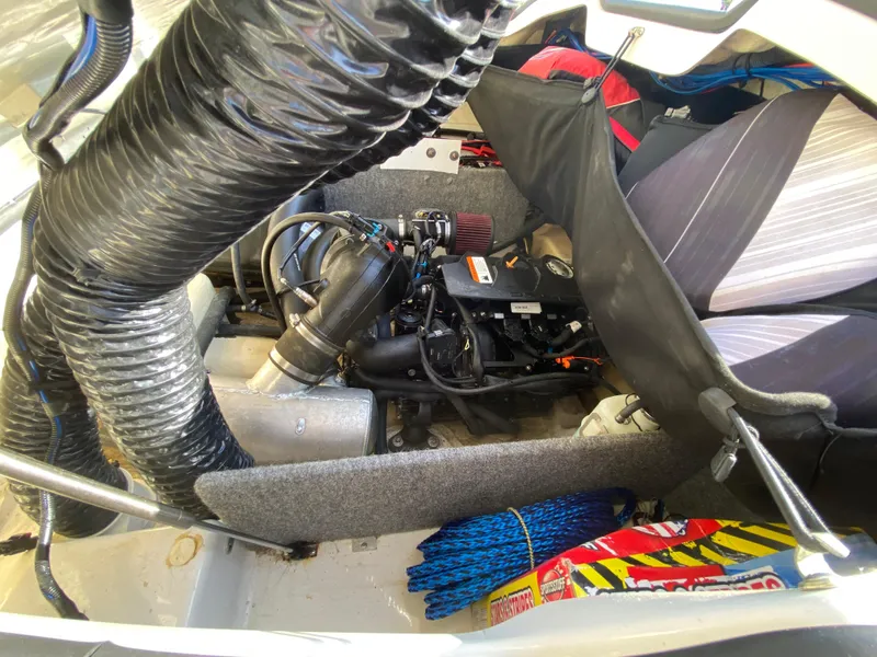 Slide: The Image of Engine compartment of a 2018 Scarab 165 boat, showing mechanical components and storage items. - 15