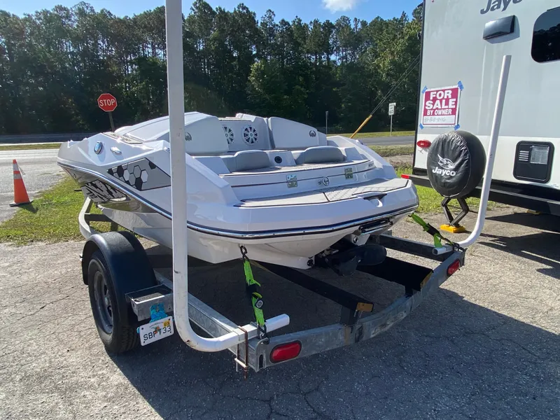 Slide: The Image of 2018 Scarab 165 boat on trailer, parked near RV with "For Sale" sign. - 4