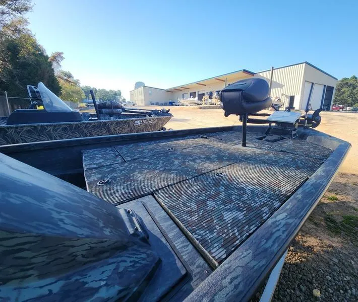 Slide: The Image of 2015 Ranger Tournament RT188 boat with camouflage deck, parked outdoors near a warehouse. - 17