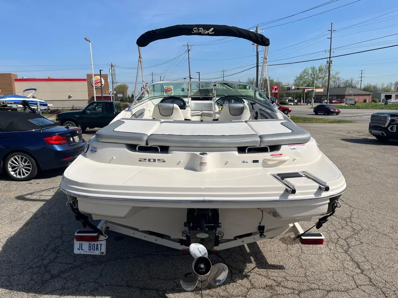 Slide: The Image of 2008 Sea Ray 205 Sport boat, rear view, parked in a lot with cars and buildings. - 2