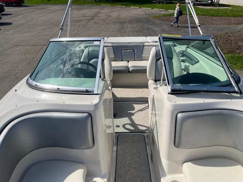 Slide: The Image of 2008 Sea Ray 205 Sport boat interior with seating and windshield, parked on pavement. - 7