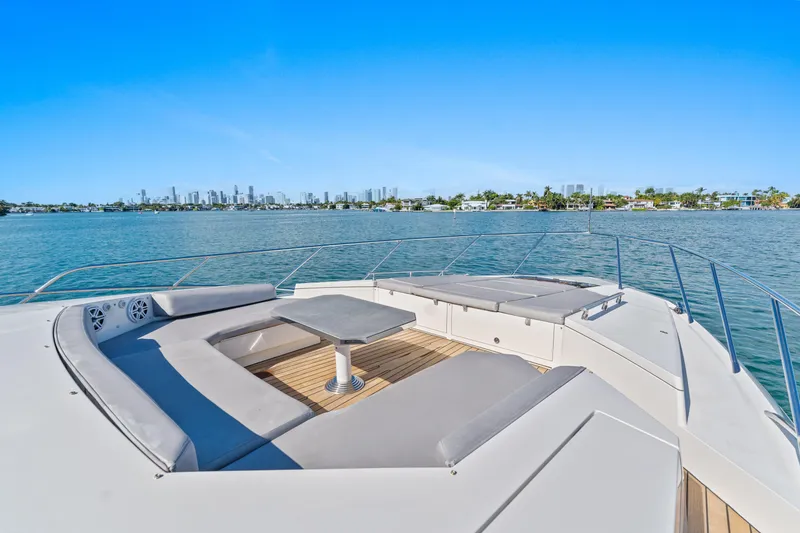 Slide: The Image of Luxurious 2012 Cheoy Lee 76 Alpha yacht deck with seating, overlooking serene waters and city skyline. - 17