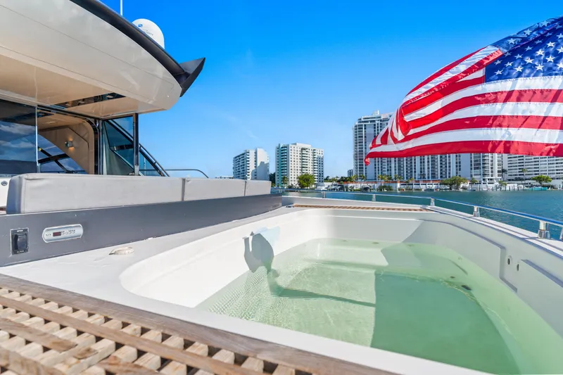 Slide: The Image of Luxurious 2012 Cheoy Lee 76 Alpha yacht with jacuzzi and American flag, city skyline in background. - 8