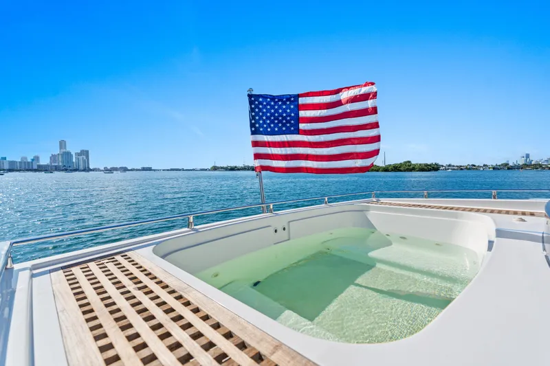 Slide: The Image of Luxury yacht Cheoy Lee 76 Alpha 2012 with American flag and jacuzzi, city skyline view. - 9
