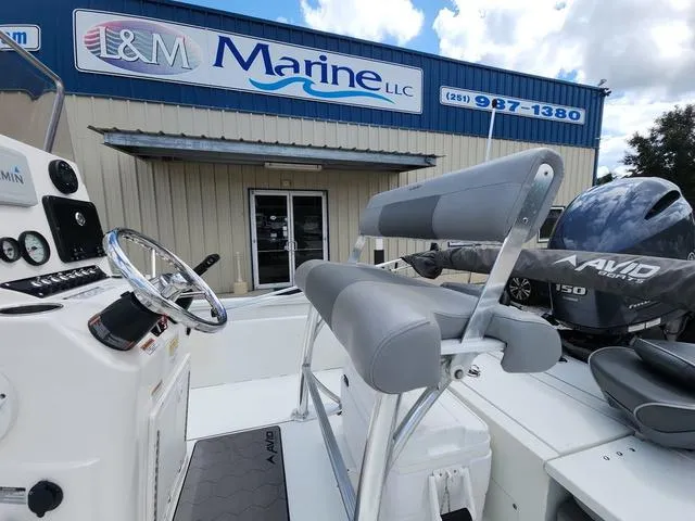 Slide: The Image of 2021 Avid 21 FS boat at I&M Marine LLC dealership, featuring helm and seating. - 11
