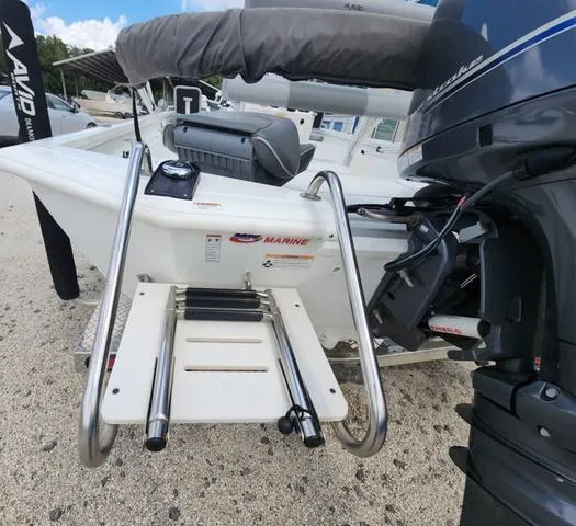Slide: The Image of Avid 21 FS 2021 boat with ladder and outboard motor on a sandy surface. - 14