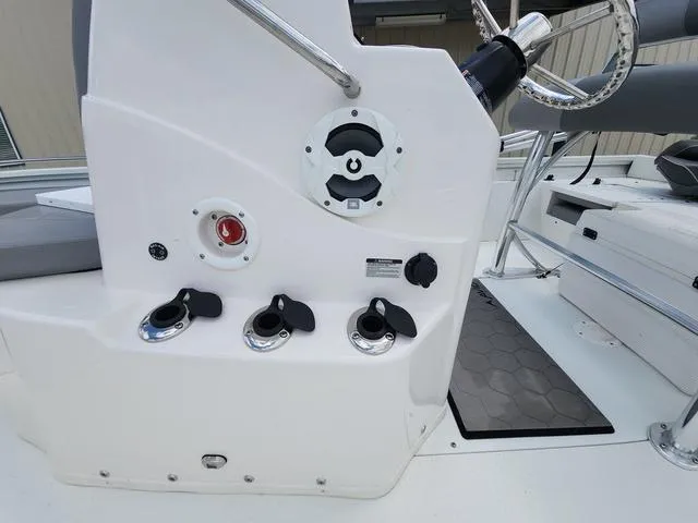 Slide: The Image of Control panel of a 2021 Avid 21 FS boat, featuring steering wheel and switches. - 15