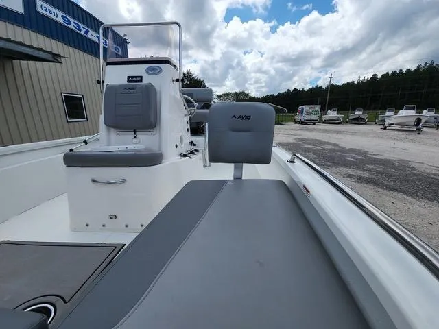 Slide: The Image of 2021 Avid 21 FS boat interior with seating and console, under a partly cloudy sky. - 18