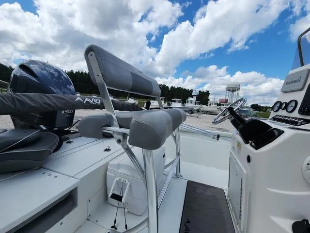 Slide: The Image of Avid 21 FS boat interior, 2021 model, featuring seating and steering console under a cloudy sky. - 22