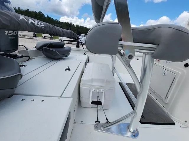 Slide: The Image of 2021 Avid 21 FS boat interior with seating and cooler, under a blue sky. - 23