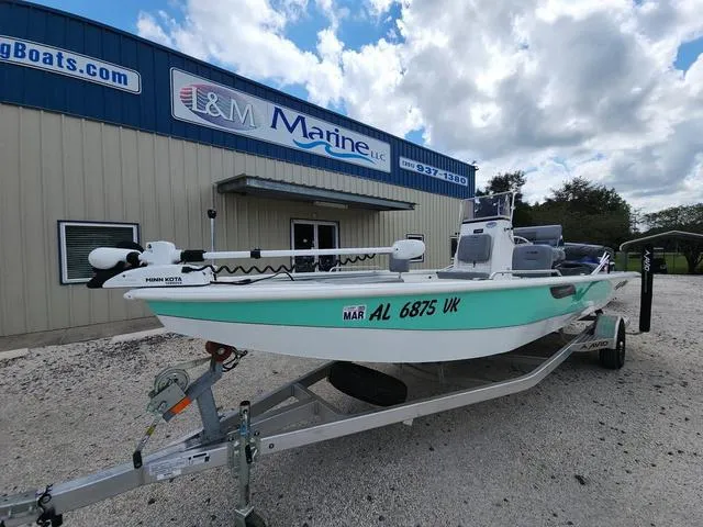 Slide: The Image of 2021 Avid 21 FS boat on trailer outside L&M Marine building under cloudy sky. - 5