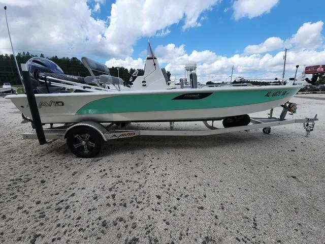 Slide: The Image of 2021 Avid 21 FS boat on trailer, parked on gravel under a partly cloudy sky. - 6