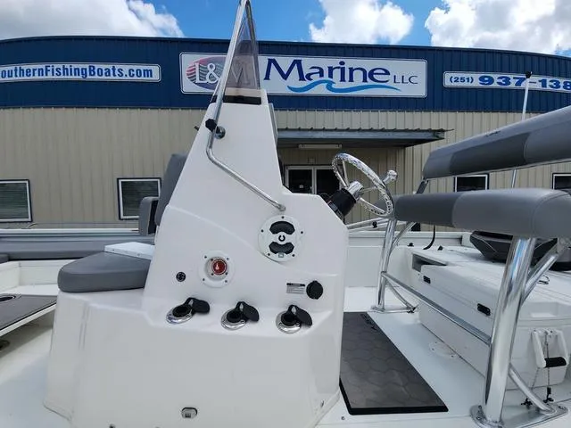 Slide: The Image of Avid 21 FS boat console with steering wheel, in front of a marine dealership. - 9