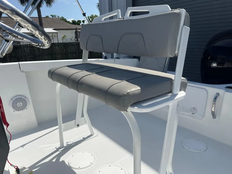 Slide: The Image of 2022 Wellcraft 202 Fisherman boat seat, gray upholstery, white frame, outdoor setting. - 8