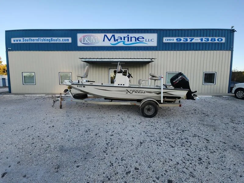 Slide: The Image of 2015 Xpress Hyper-Lift Bay Series H18B boat on trailer outside marine shop. - 0