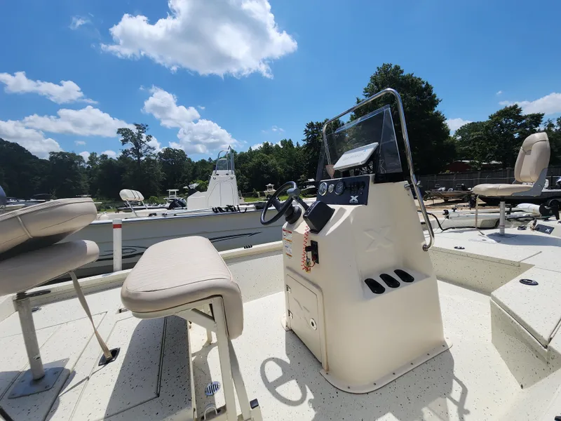 Slide: The Image of 2015 Xpress Hyper-Lift Bay Series H18B boat interior with steering console and seating. - 12