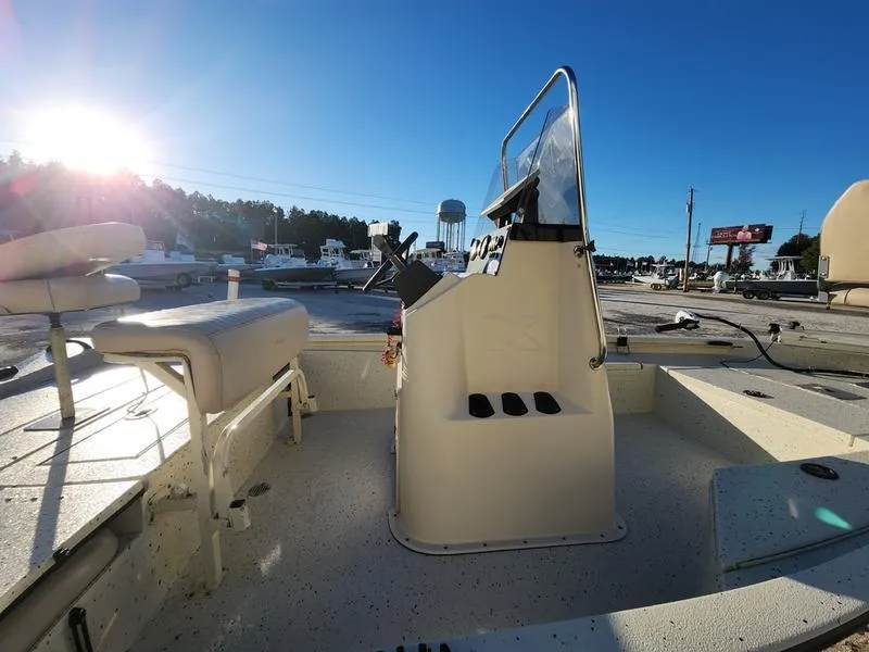 Slide: The Image of 2015 Xpress Hyper-Lift Bay Series H18B boat interior with console and seating, sunny day. - 16