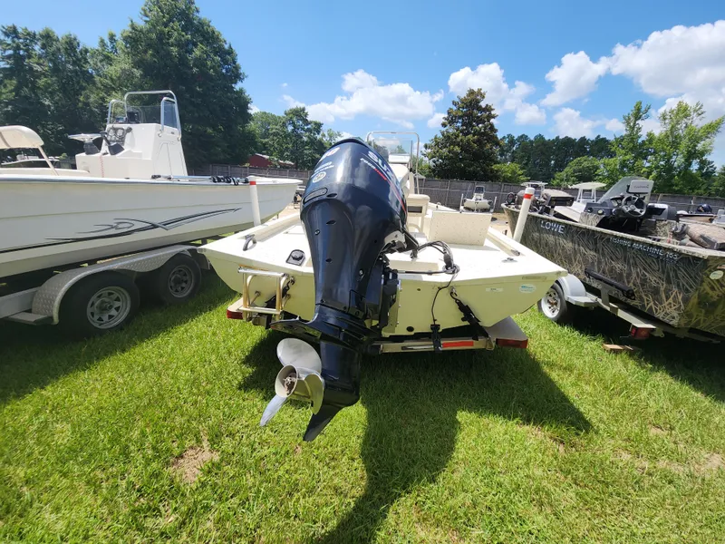 Slide: The Image of 2015 Xpress Hyper-Lift Bay Series H18B boat with outboard motor, parked on grass. - 7