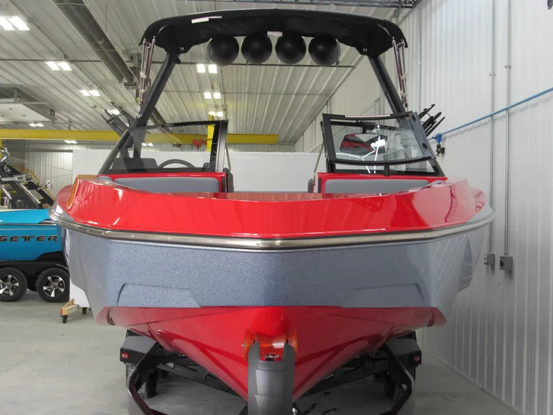Slide: The Image of 2024 Axis T235 boat in a showroom, featuring a sleek red and gray design. - 1