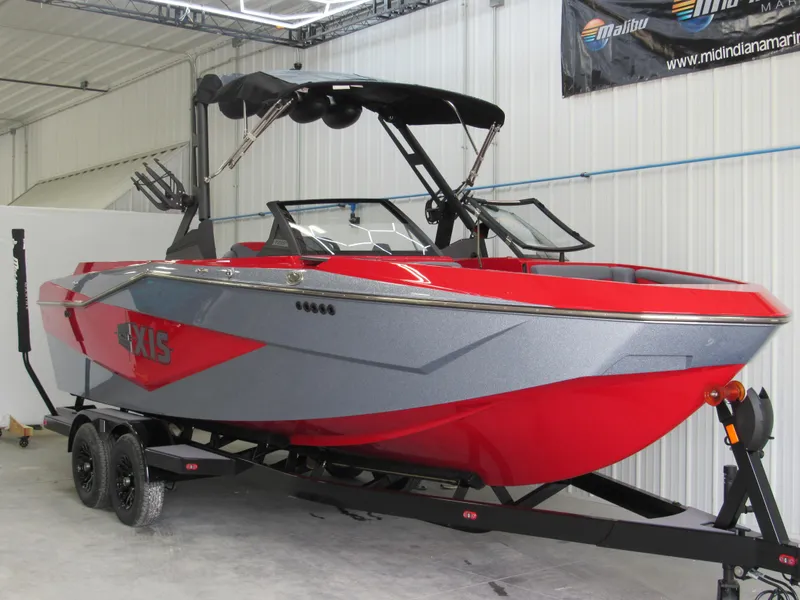 Slide: The Image of 2024 Axis T235 boat in red and gray on a trailer in a garage. - 2