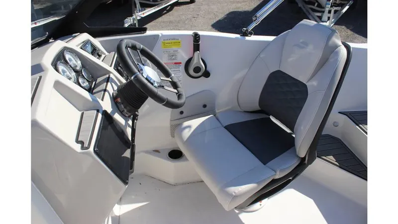 Slide: The Image of 2025 Starcraft SVX 190 OB DC boat cockpit with steering wheel and cushioned seat. - 11