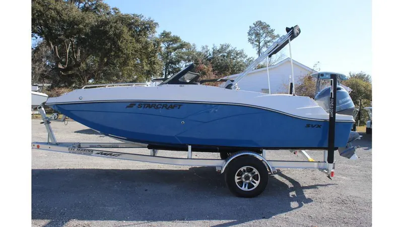 Slide: The Image of 2025 Starcraft SVX 190 OB DC boat on trailer, blue and white design. - 2