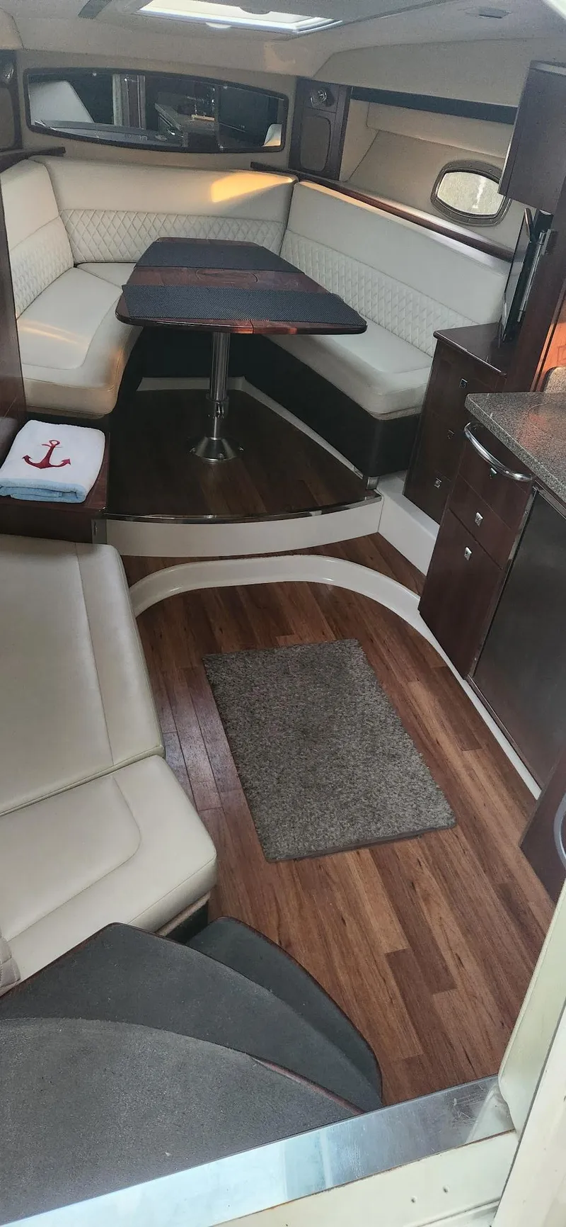 Slide: The Image of 2014 Chaparral 330 Signature Cruiser interior with elegant seating and wooden flooring. - 12
