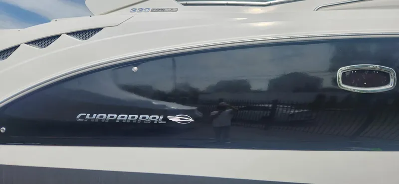 Slide: The Image of 2014 Chaparral 330 Signature Cruiser side view with logo and sleek design. - 14