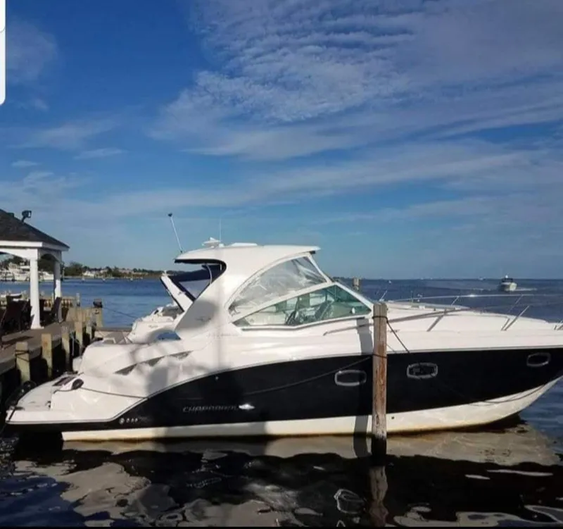 Slide: The Image of 2014 Chaparral 330 Signature Cruiser docked by the waterfront under a clear blue sky. - 16